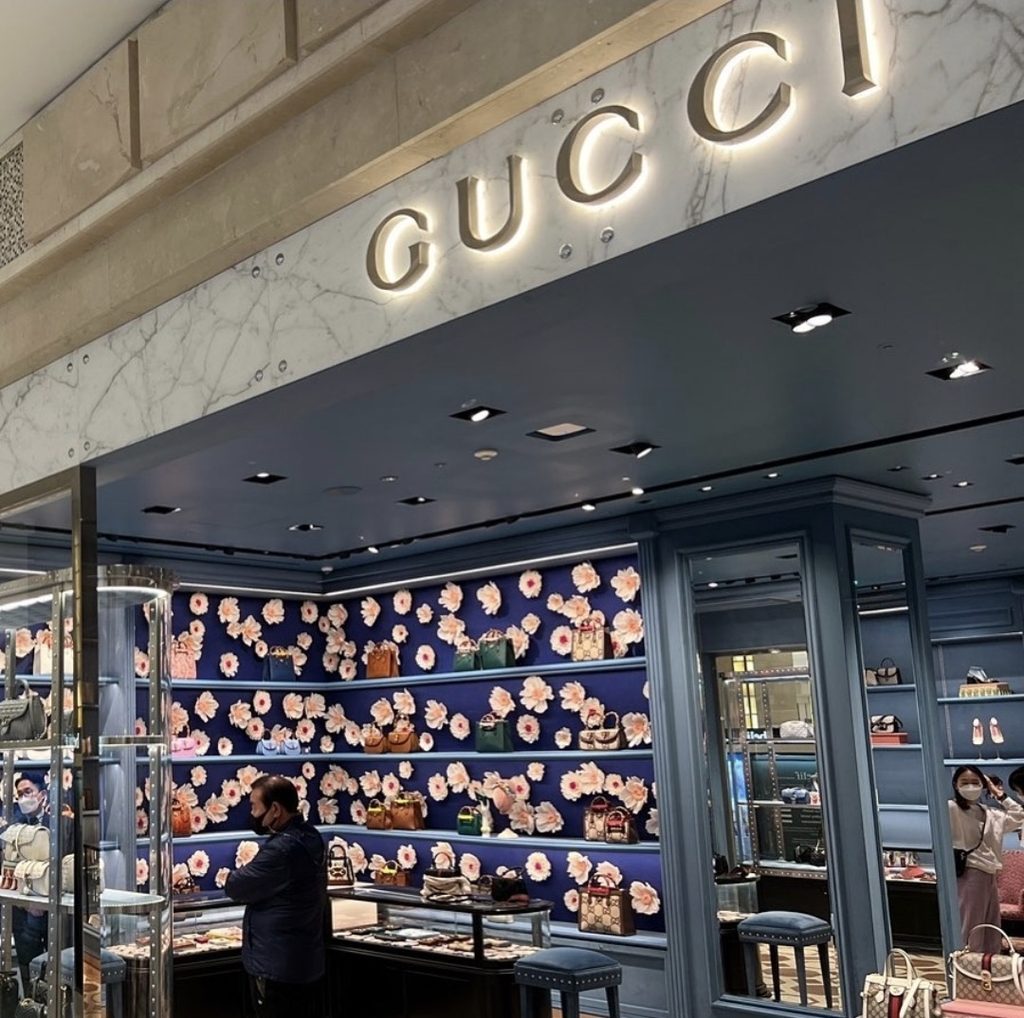 Large handmade paper flower display installed inside a Gucci store