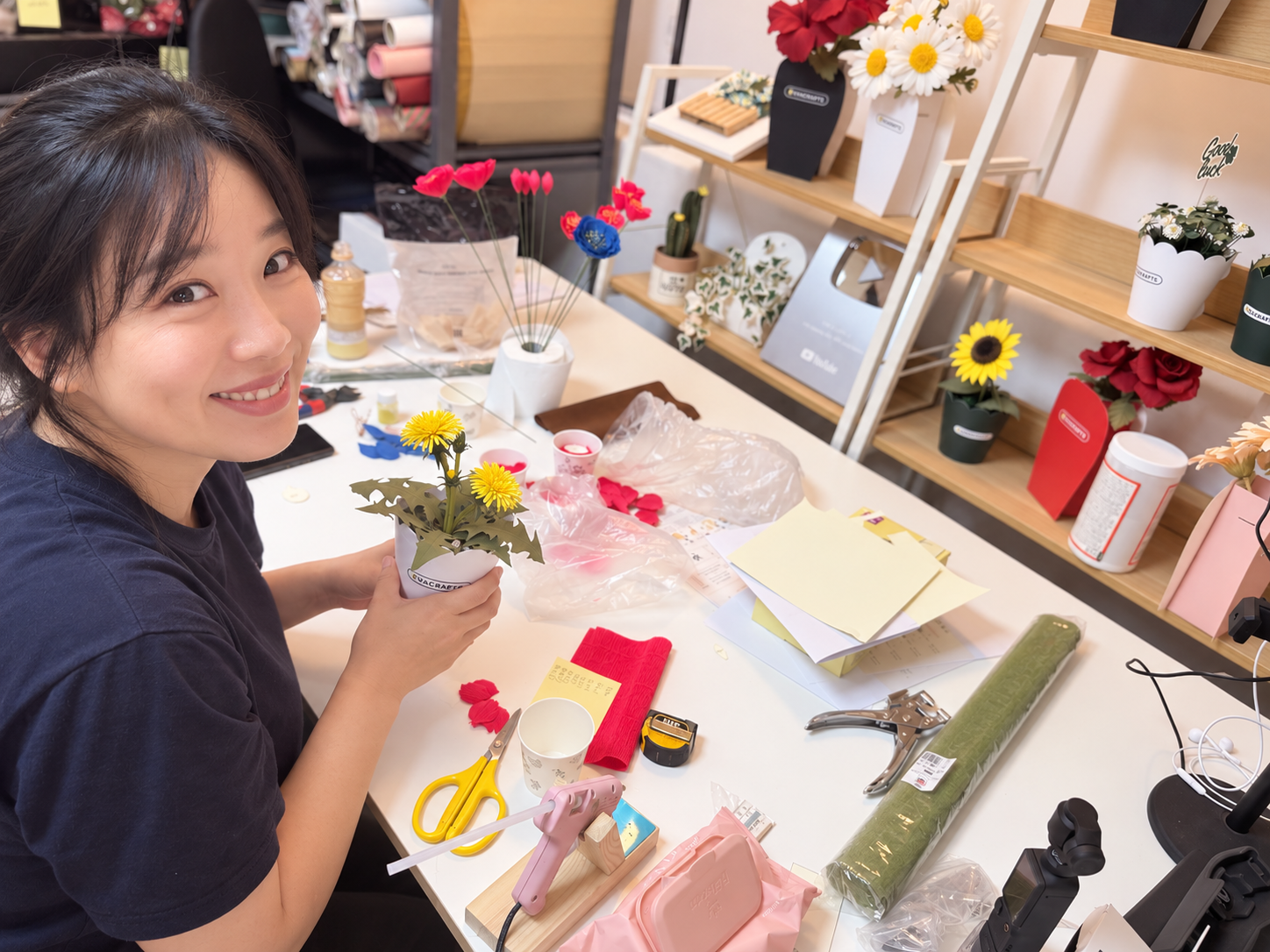 Korean paper flower designer Eva working in her studio surrounded by handmade paper flowers