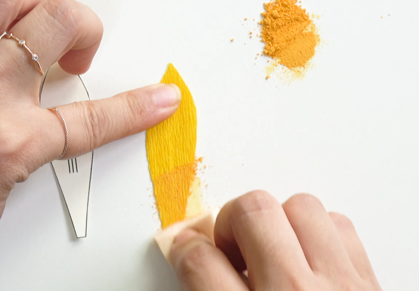 Attaching the first layer of yellow petals around the crepe paper sunflower center