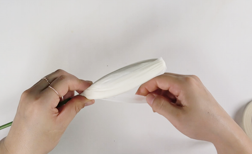 Attaching white crepe paper lily petals around the handmade pistil and stamens