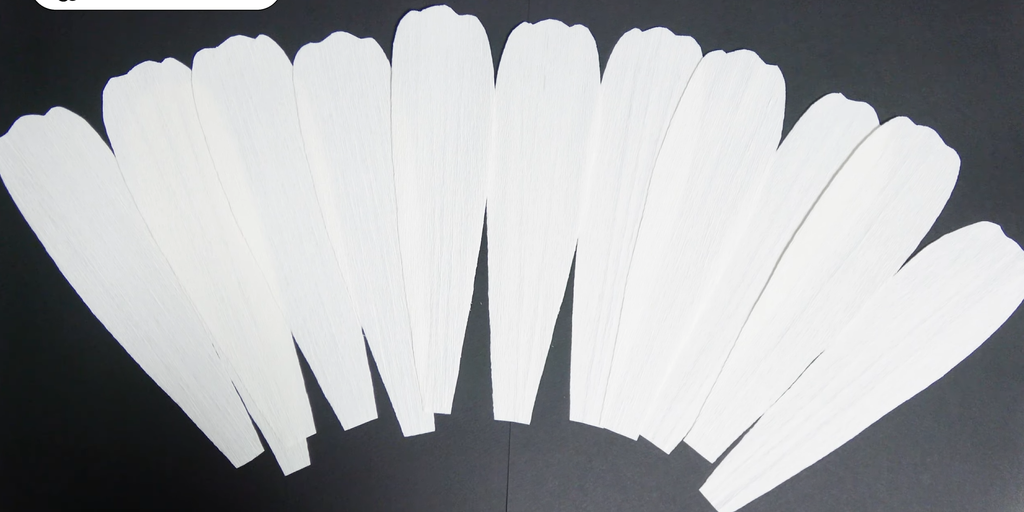 Twelve white crepe paper petals prepared for a giant daisy flower