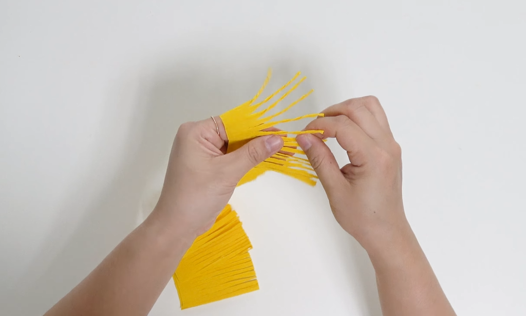 Separating the thin yellow crepe paper fringe for a giant daisy center