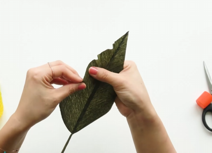 Twisting the edge of a crepe paper calla lily leaf to create a natural wavy shape