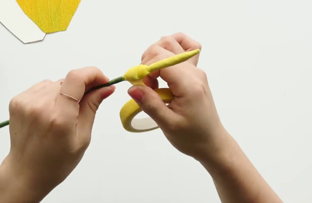 Shaping yellow floral tape into a rounded base for the calla lily flower center