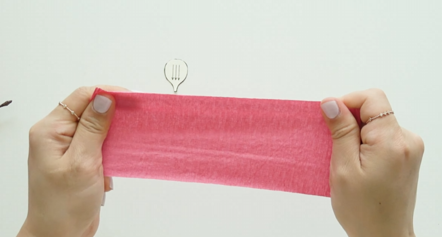 Stretching pink crepe paper before making plum blossom petals
