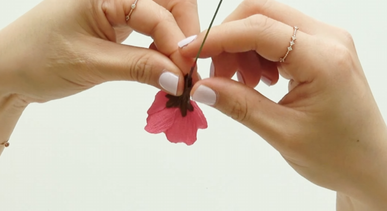 Wrapping a brown crepe paper sepal around the base of the flower