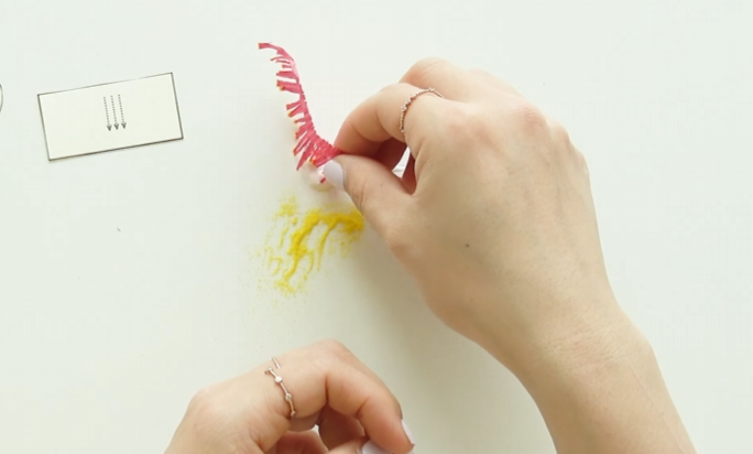 Adding yellow decorative sand to crepe paper stamen tips for pollen
