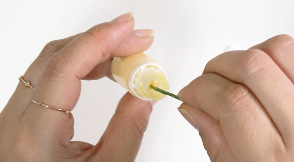 Applying wood glue to the looped tip of green floral wire for the lisianthus stamens