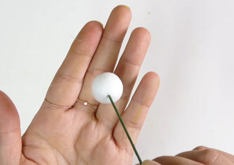 Attaching a 2 cm styrofoam ball to green floral wire to make a lisianthus bud