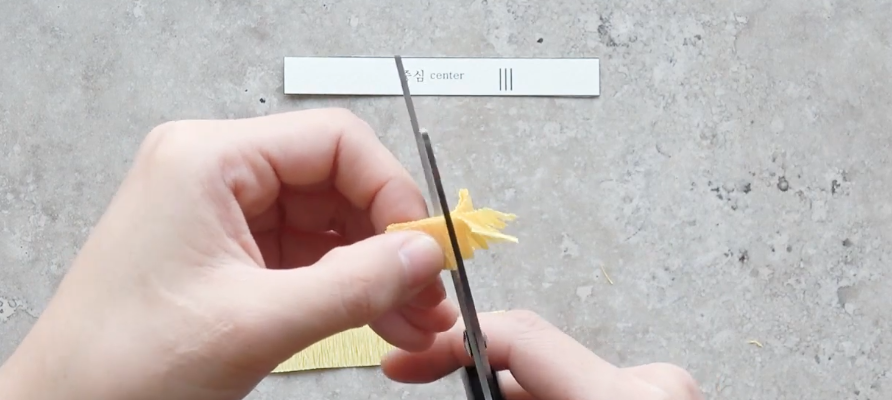 Cutting fine fringes into ivory crepe paper to make the cosmos flower center