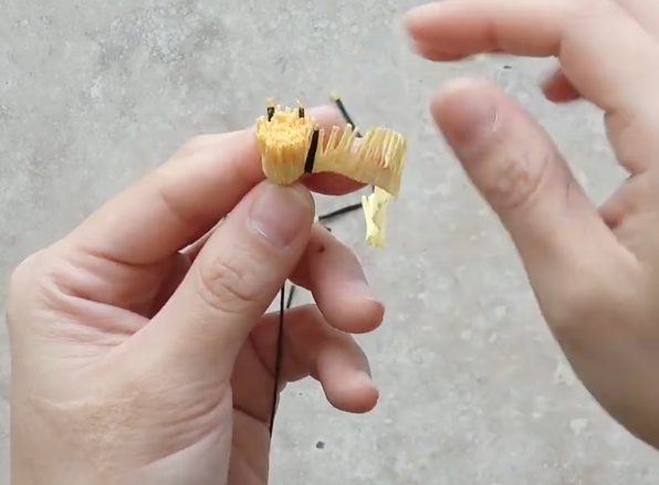 Wrapping ivory crepe paper stamens around green wire and adding black stamen details