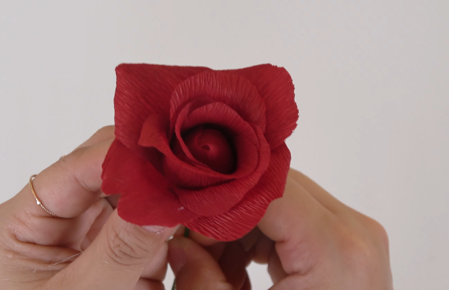 Layering and gluing crepe paper rose petals to build a realistic flower