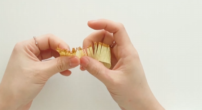 Rolling the fringed crepe paper between fingers to create natural stamen texture