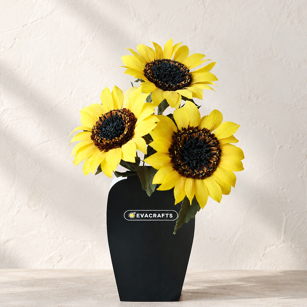 Realistic crepe paper sunflowers arranged in a black vase