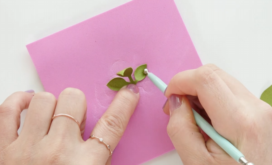 Shaping green cardstock leaves with a ball tool for the cherry blossom wreath