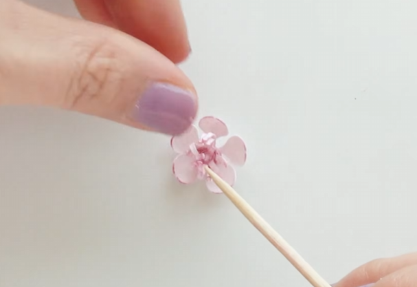 Opening the petals around the stamen to shape a finished paper cherry blossom