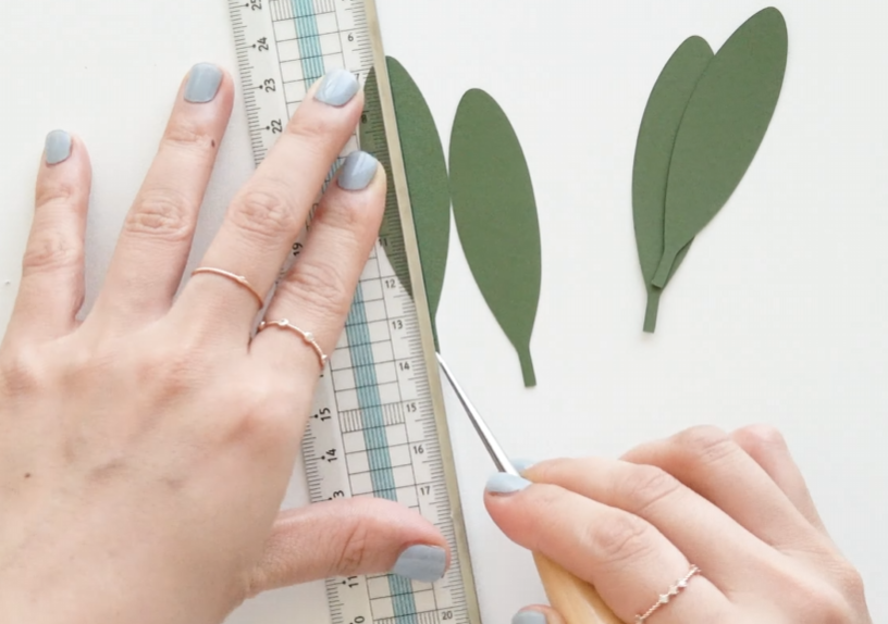 Creating a center vein on green cardstock leaves with a pointed tool