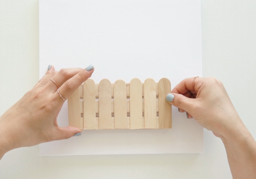 Positioning the wooden fence on the bottom of a white canvas