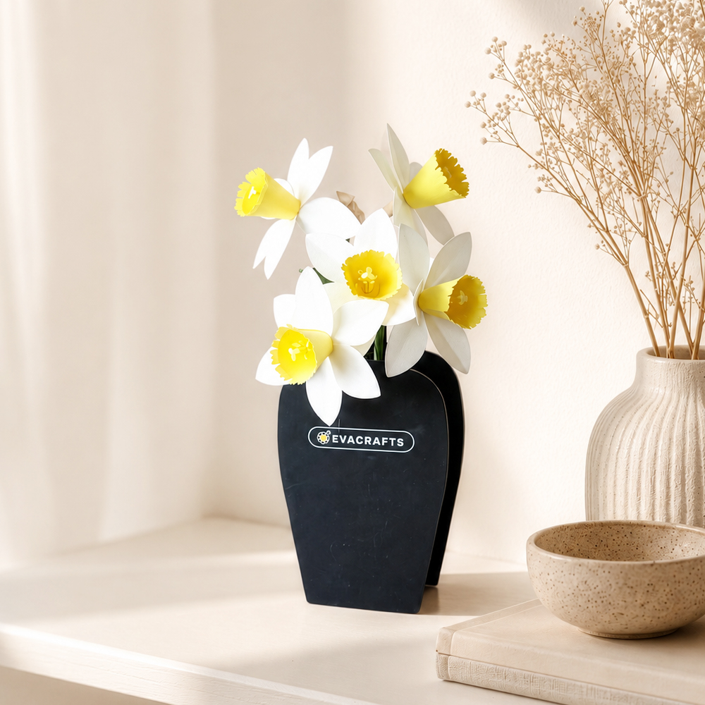 Handmade white paper daffodils with yellow trumpet centers arranged in a black vase for home decor