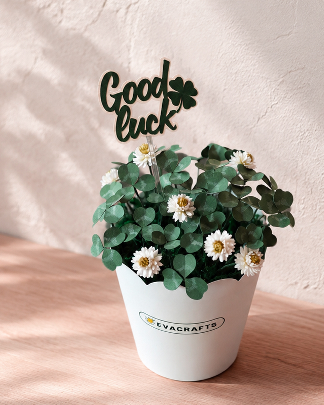 Paper shamrock flower pot with small white flowers and a Good Luck topper
