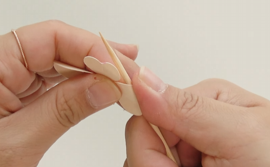 Shaping the folded ivory paper dogwood petals with a wooden skewer to create a natural curve