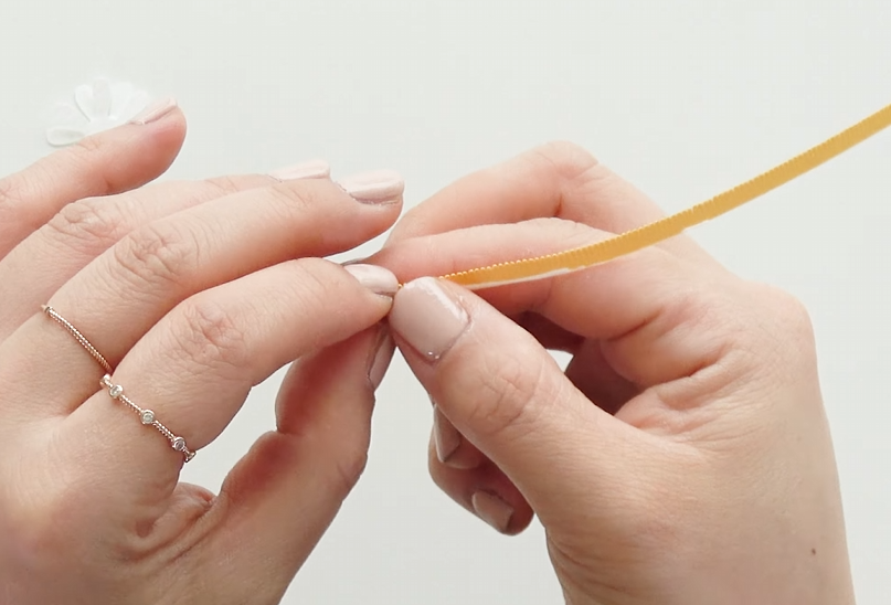Rolling a yellow cardstock strip to make the center of a daisy paper flower