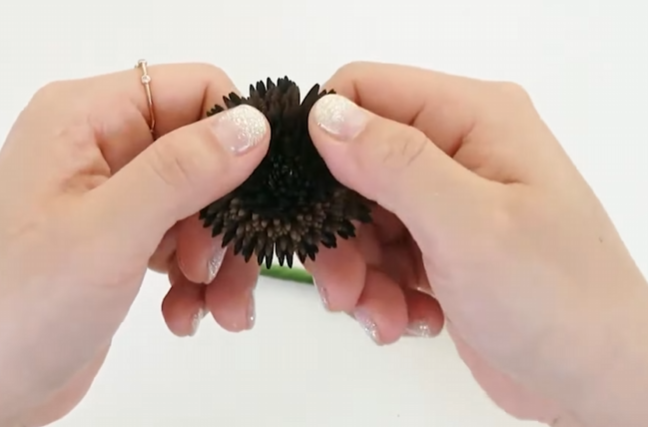 Gently spreading the layered paper sunflower center with fingers to create a rounded shape