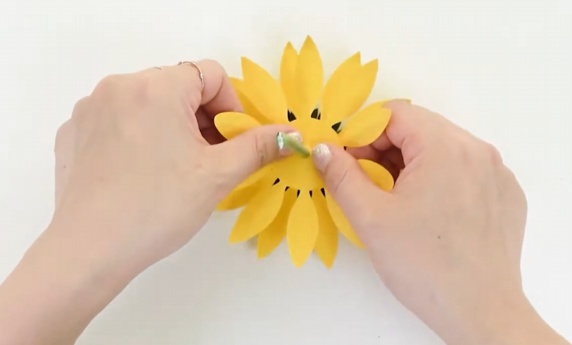 Attaching two layers of yellow cardstock petals underneath the sunflower center