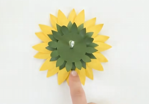 Attaching green cardstock sepals to the back of the 3D paper sunflower