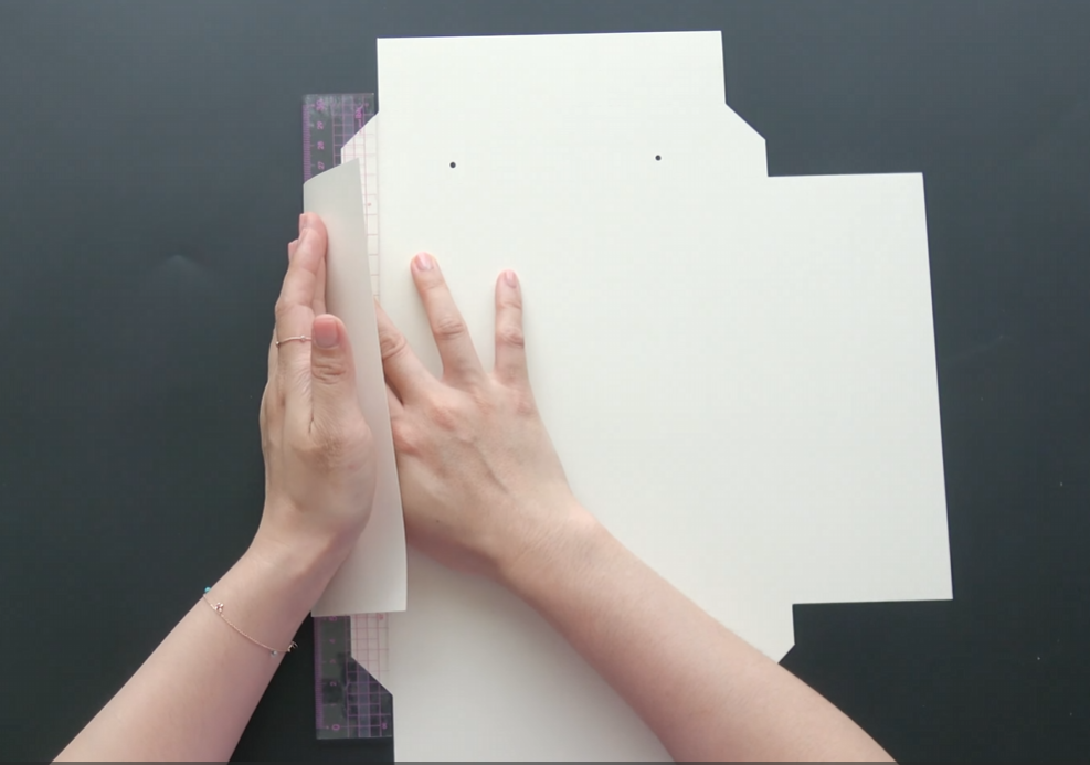 Folding white cardstock along the frame pattern to make paper flower wall art