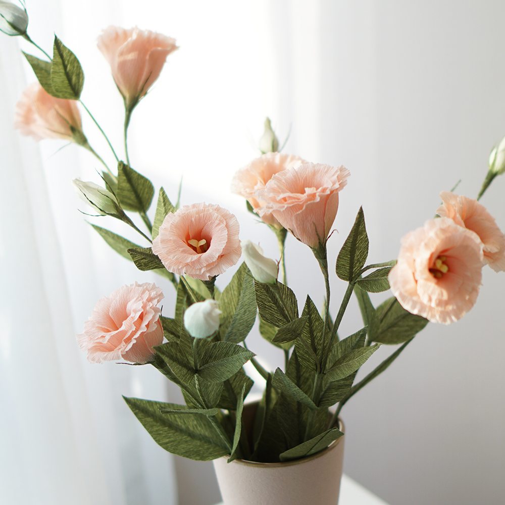Handmade peach pink crepe paper lisianthus flowers arranged in a vase