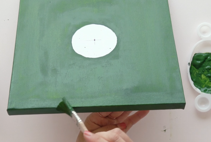 Painting the square canvas green while leaving the sunflower center unpainted