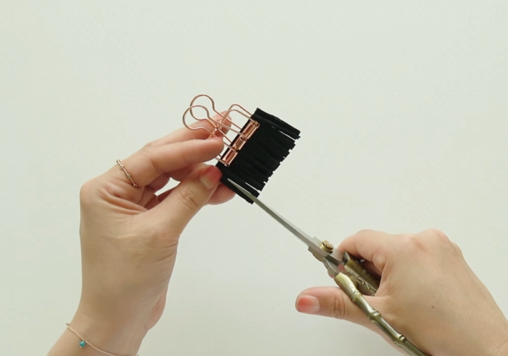 Cutting black crepe paper into fine fringes for the sunflower center
