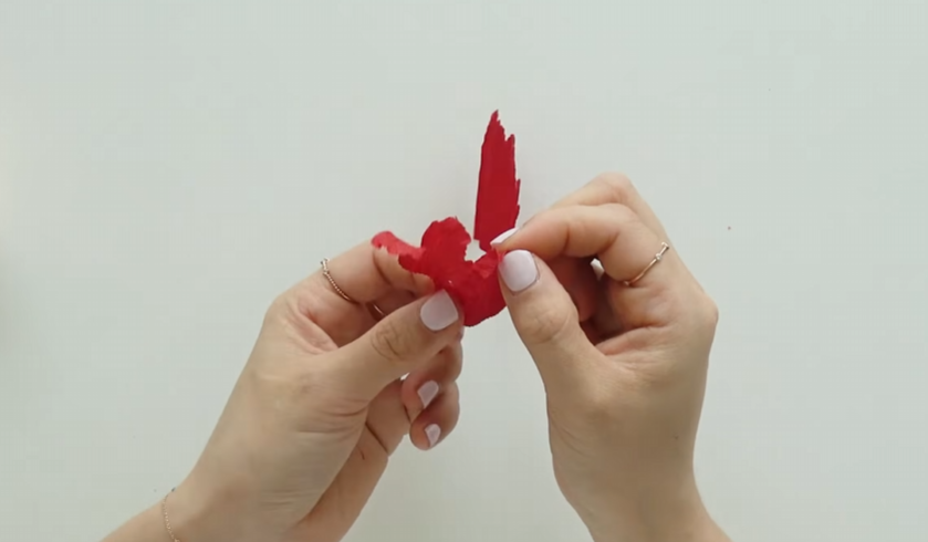 Twisting and stretching crepe paper to create natural ruffled petal edges