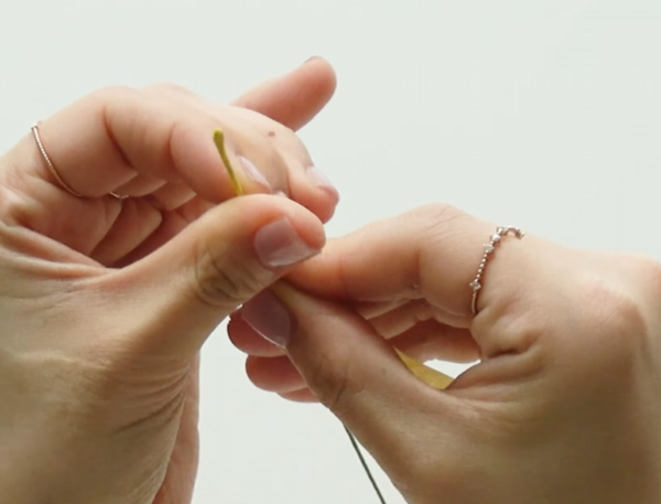 Wrapping green floral wire with yellow floral tape for the flower center