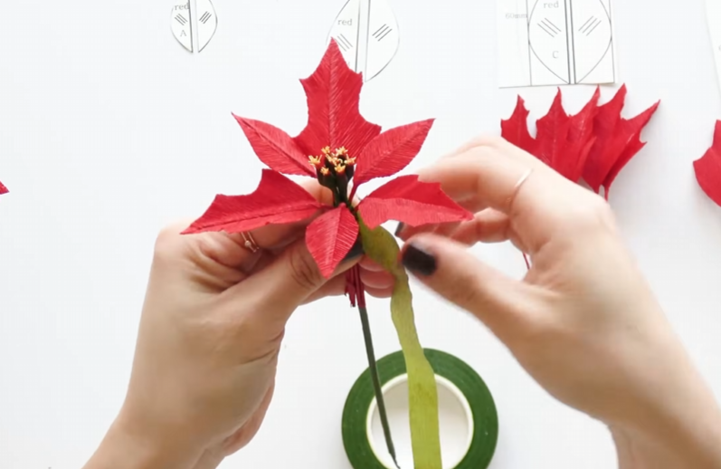 Arranging the first pointed red paper petals around the yellow flower center