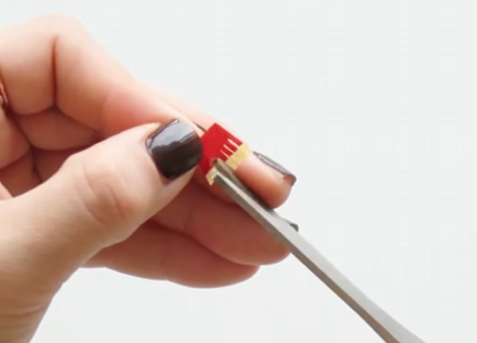 Cutting fine fringes into layered red and yellow paper with small craft scissors