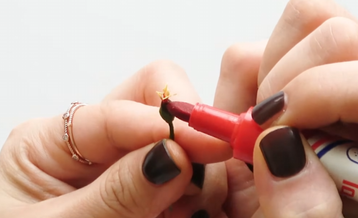 Adding red permanent marker color to the base of a tiny handmade poinsettia center