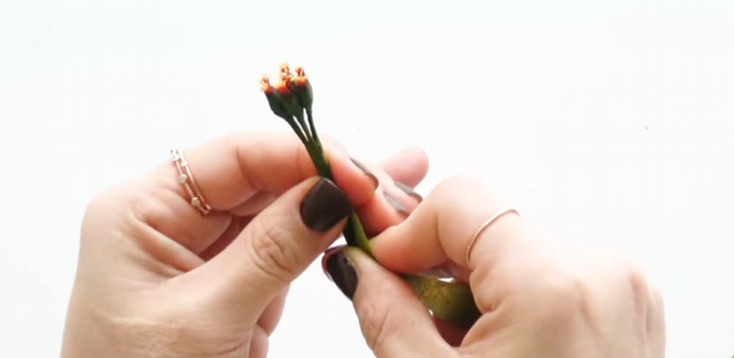 Grouping six small handmade poinsettia stamens together with green floral tape