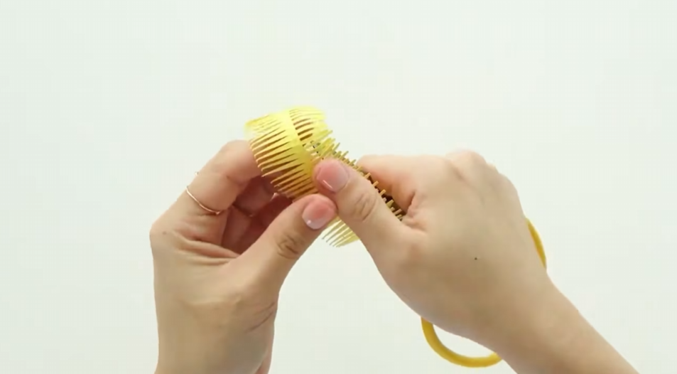 Curving yellow cardstock petals by hand to create a fuller paper flower shape
